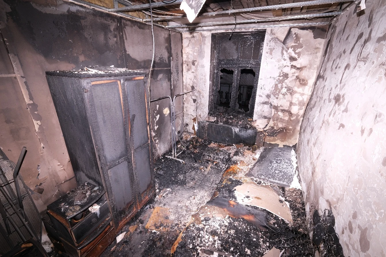 White, blackened and paper-faced gypsum board surfaces after a real fire